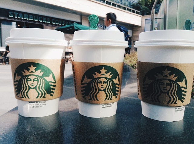 Three cups of Starbucks coffee lined up in a row.